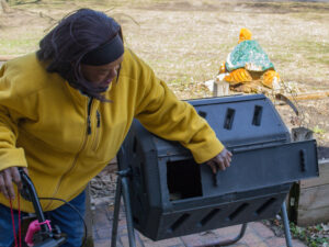 Resident Angerline tending to compost for the upcoming spring community gardening.