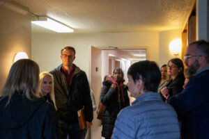 Several people standing around and chatting in apartment unit