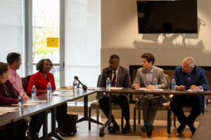 Officials seated at a table chatting 