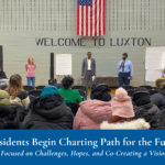 Community meeting in a gymnasium with four speakers and attendees seated. Text at bottom reads "Glendale Residents Begin Charting Path for the Future, Listening Sessions Focused on Challenges, Hopes, and Co-Creating a Vision"