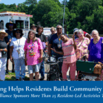 A group of adults poses together outdoors near a riverboat, with trees in the background; text banner reads: Grant Funding Helps Residents Build Community, Highrise Health Alliance Sponsors More Than 25 Resident-Led Activities This Year