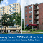 Two mid-rise apartment buildings: one beige with multiple windows and trees in front, the other red brick with balconies and a maroon awning at the entrance.