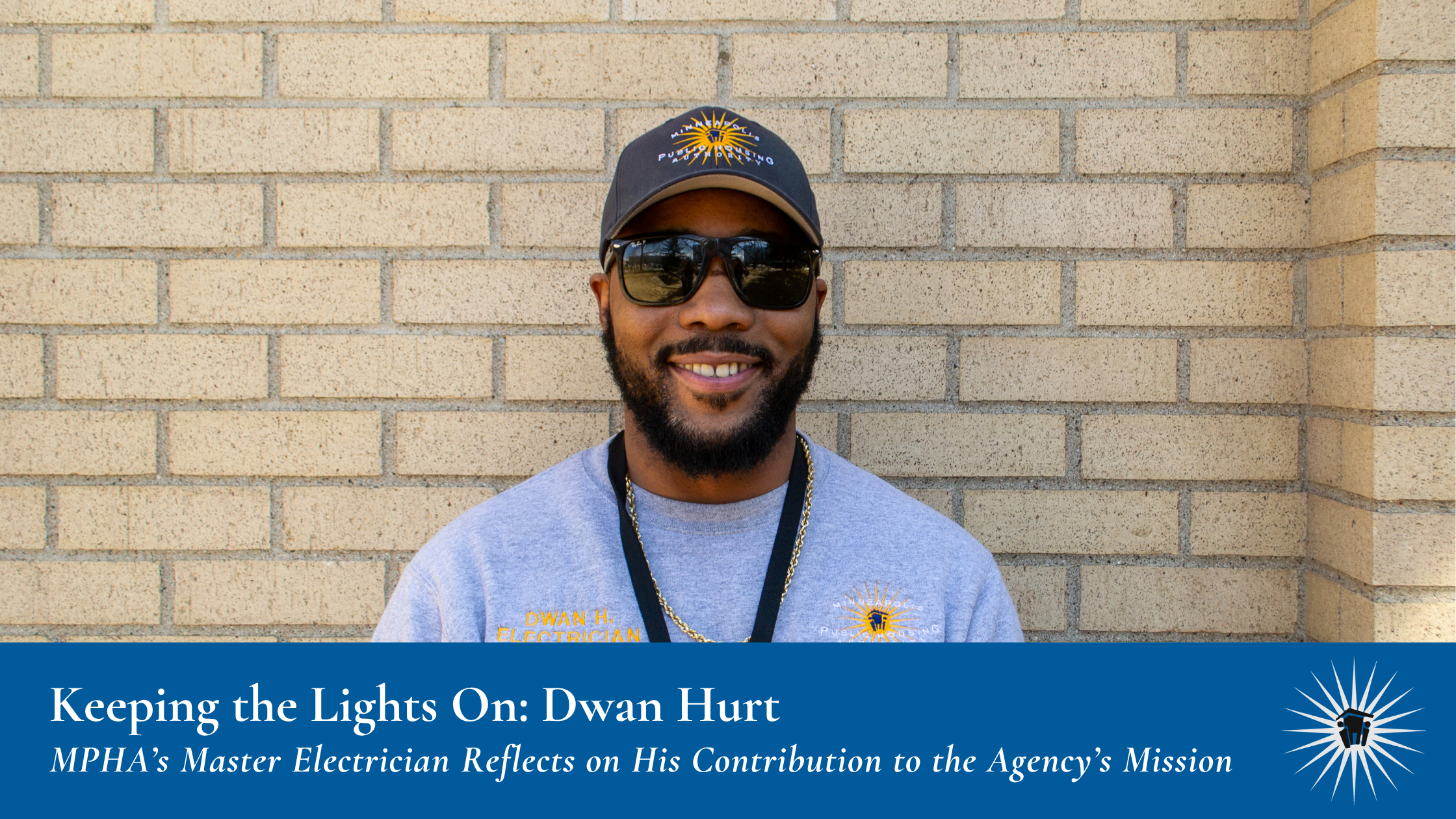 Dwan Hurt_MPHA Blog Graphic A man wearing sunglasses, a cap, and a gray shirt stands smiling in front of a brick wall. A banner at the bottom reads: "Keeping the Lights On: Dwan Hurt. MPHA’s Master Electrician Reflects on His Contribution to the Agency’s Mission"