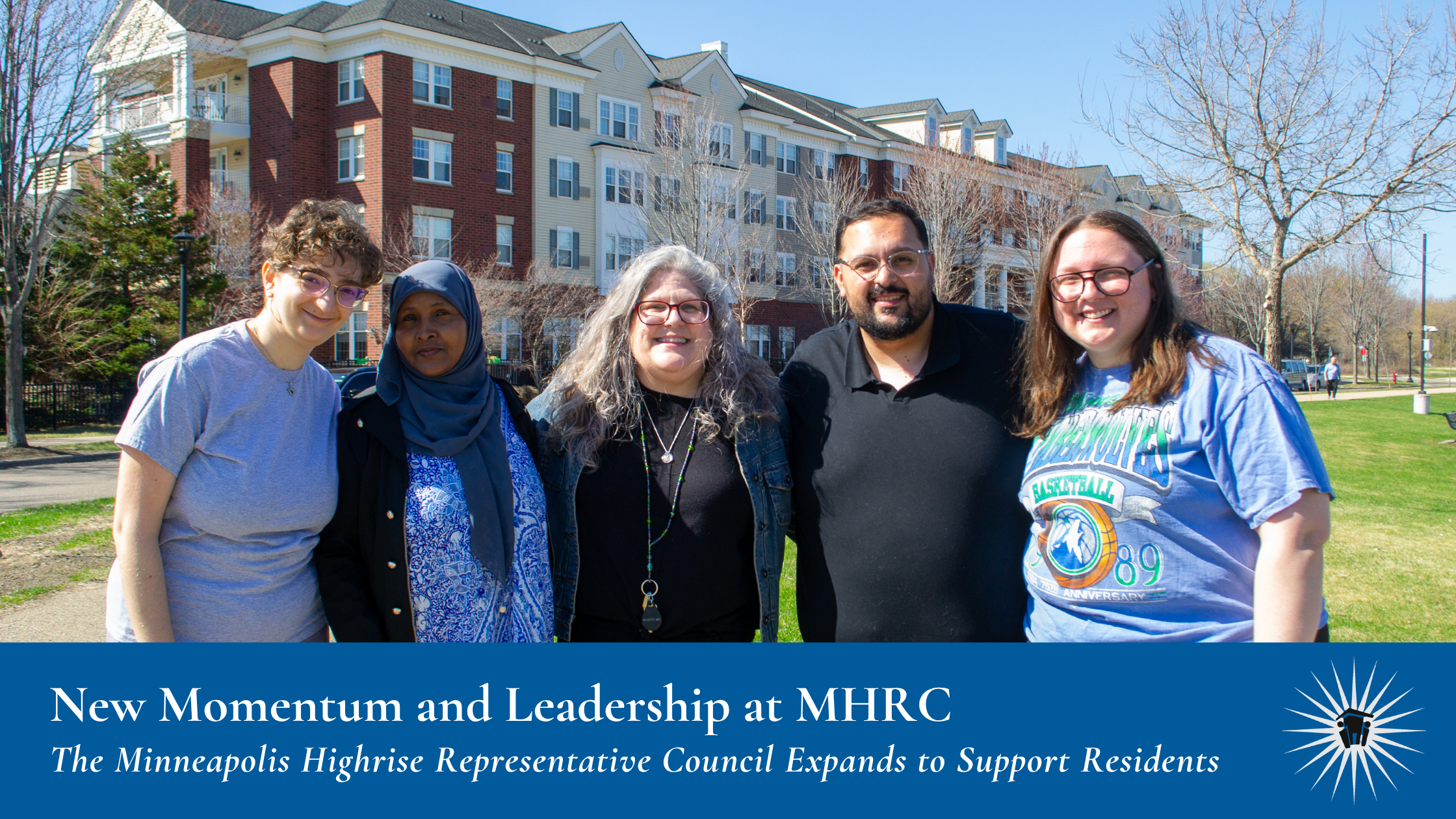 Five individuals stand together outside, in front of a large apartment complex